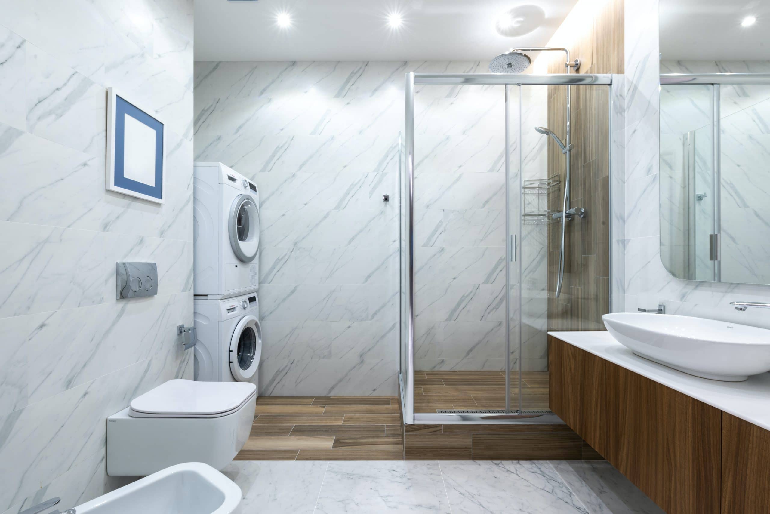 当代卫生间卫生间在铺磁砖的墙壁附近反对与水槽的内阁与墙壁与玻璃墙和洗衣机的淋浴房附近